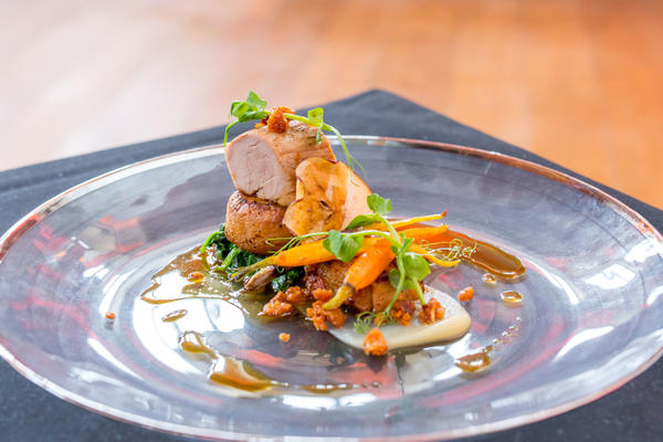 Photo of a beautifully presented roast pork dish on a large plate