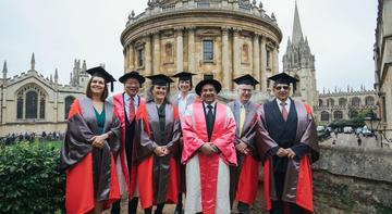 Photo of a group of people in academic dress posing outside of the Sheldonian as part of Encaenia 2019