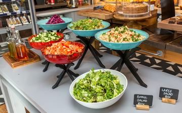 Photo of assorted salads in coloured bowls on a table